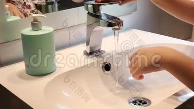 女孩用水洗手，以保护自己免受病毒和电晕病毒